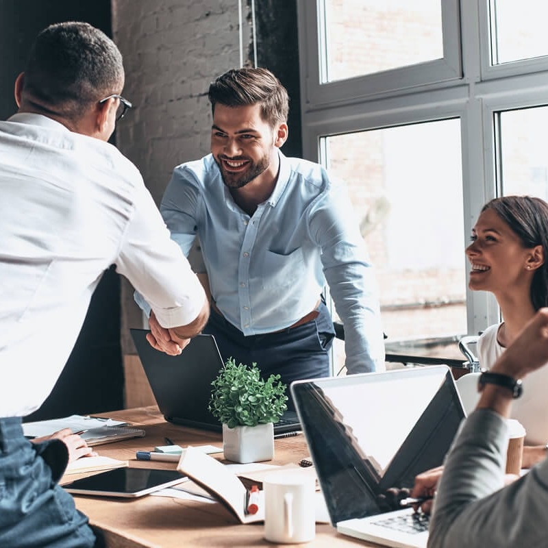Handshake over table in office Hands making towers with building blocks